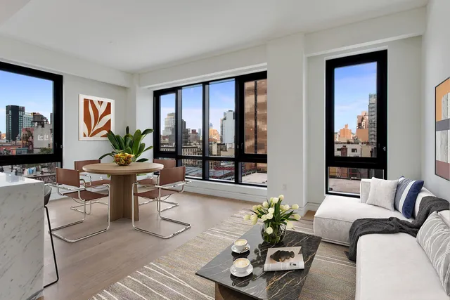a living room with furniture large window and wooden floor
