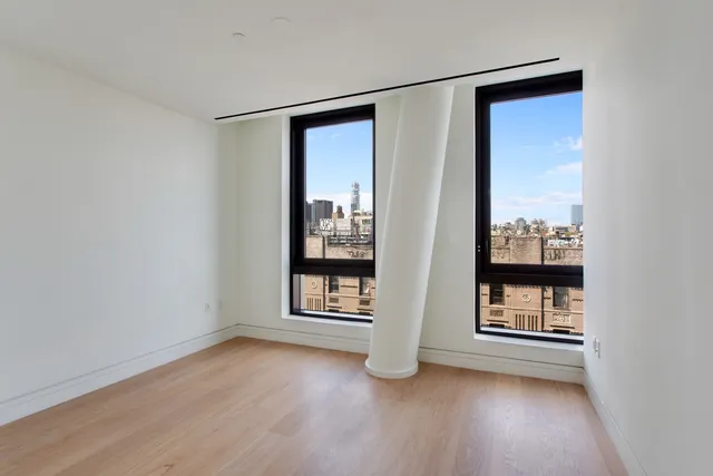a bedroom with a bed a chandelier and a window