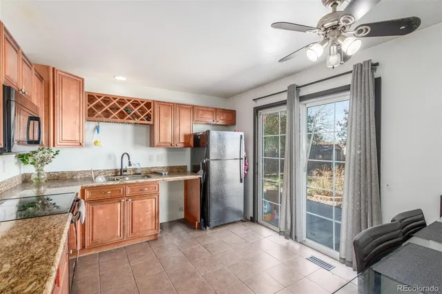 a kitchen with stainless steel appliances granite countertop a refrigerator a sink a stove and island