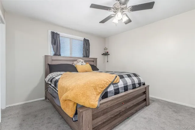 a bed sitting in a bedroom next to a window with a chandelier