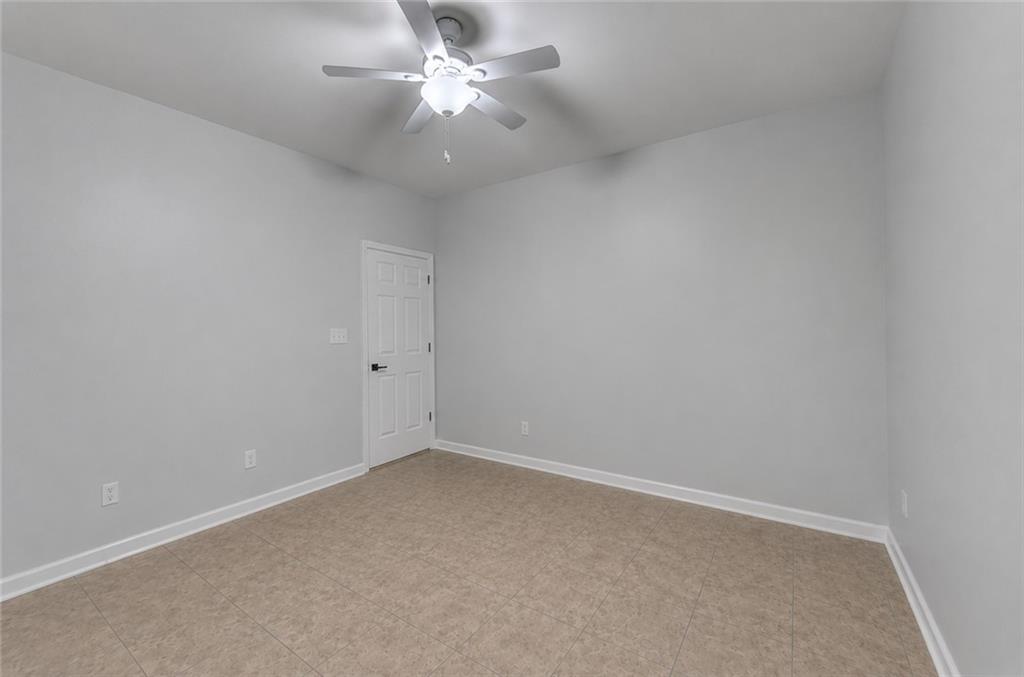 3977 Howell Park Road Duluth, GA 30096 - Photo 5 of 25 an empty room with a window and a ceiling fan
