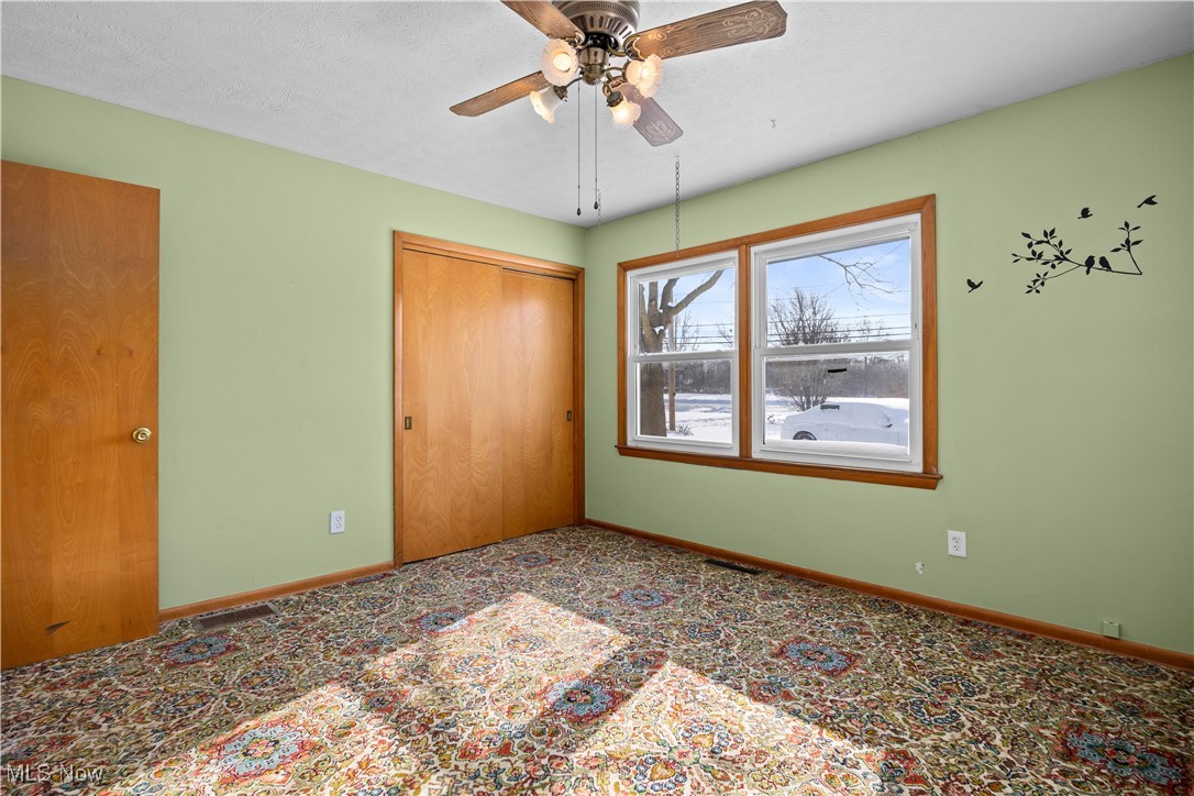 14015 West Lake Road Vermilion, OH 44089 - Photo 31 of 50 Unfurnished bedroom featuring a closet, a ceiling fan, and carpet