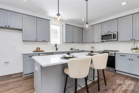 a kitchen with stainless steel appliances granite countertop a sink stove and microwave