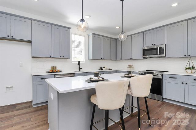 a kitchen with stainless steel appliances granite countertop a sink stove and microwave