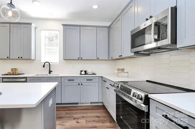 a kitchen with kitchen island granite countertop a sink a center island and cabinets