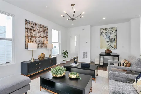 a living room with furniture and a chandelier