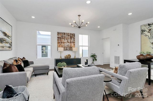 a living room with furniture and a chandelier