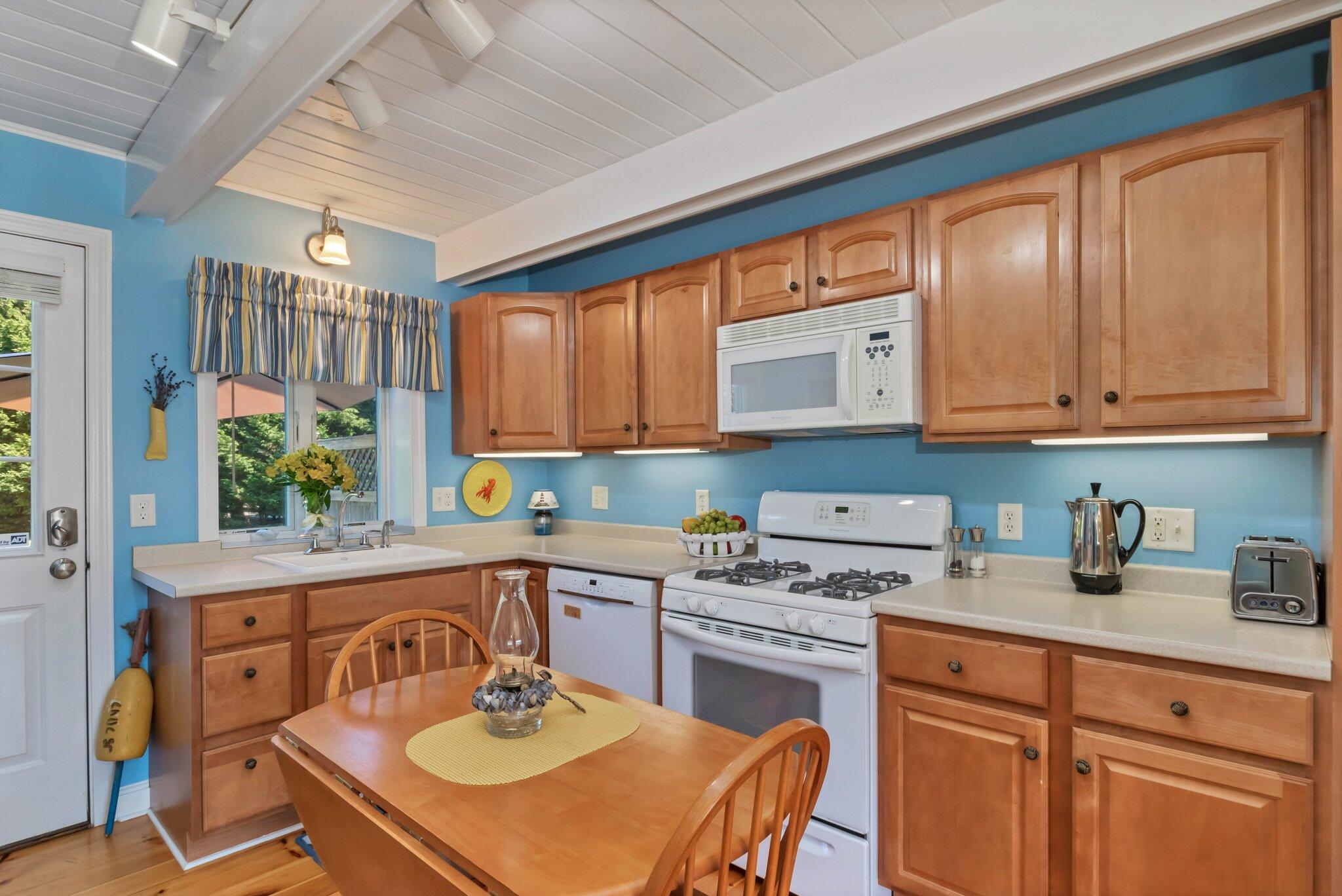 153 Jericho Path, Unit 8U Falmouth, MA 02540 - Photo 12 of 52 a kitchen with a sink a stove cabinets dining table and chairs