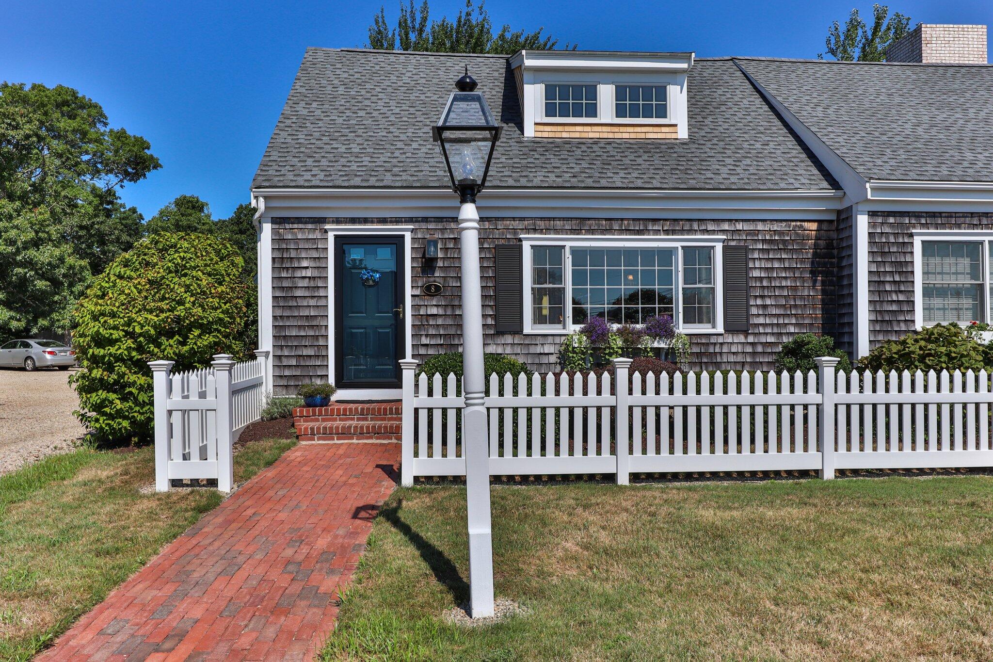 153 Jericho Path, Unit 8U Falmouth, MA 02540 - Photo 2 of 52 a front view of a house with a garden