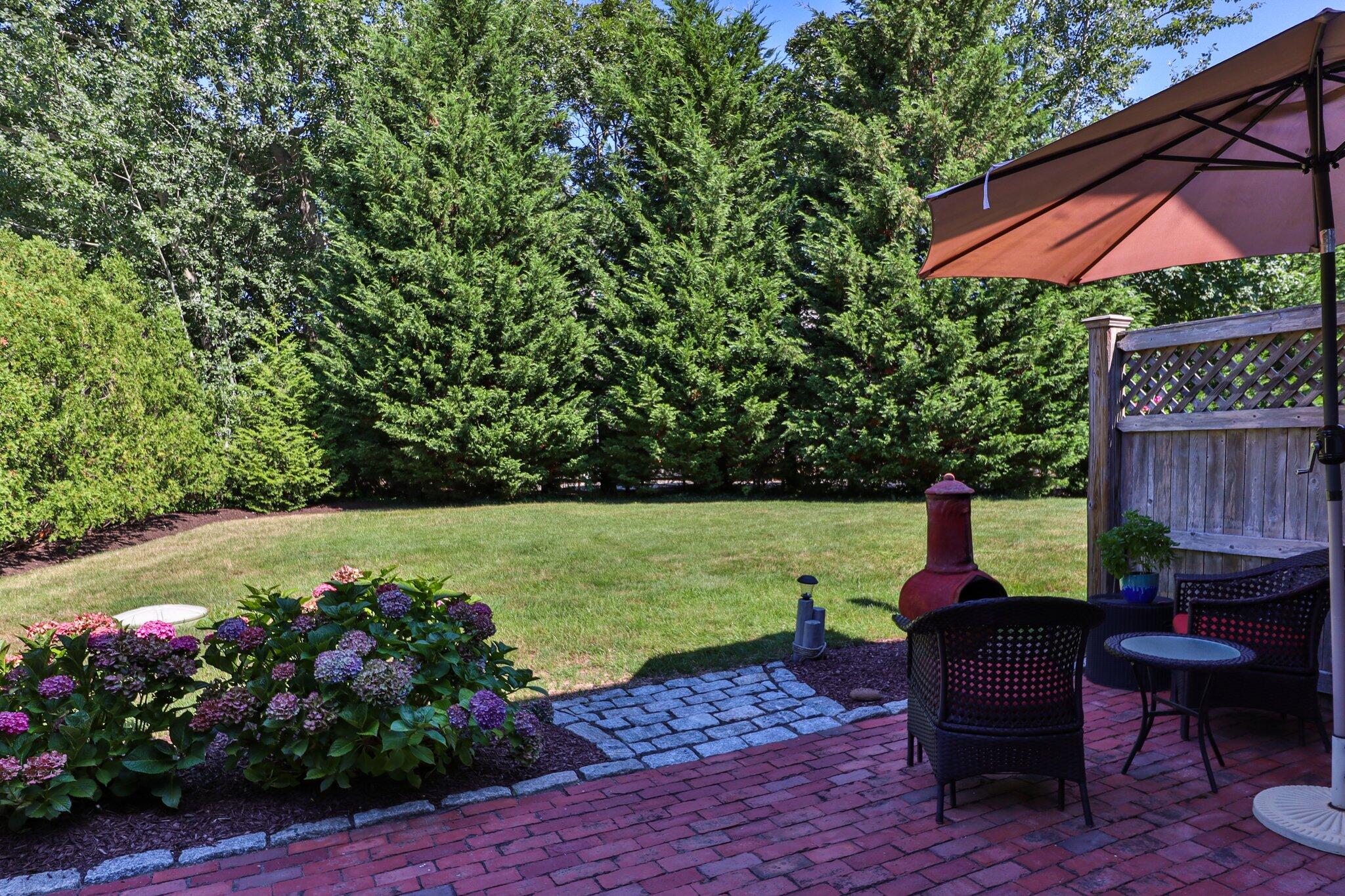 153 Jericho Path, Unit 8U Falmouth, MA 02540 - Photo 25 of 52 a backyard of a house with wooden floor and outdoor seating