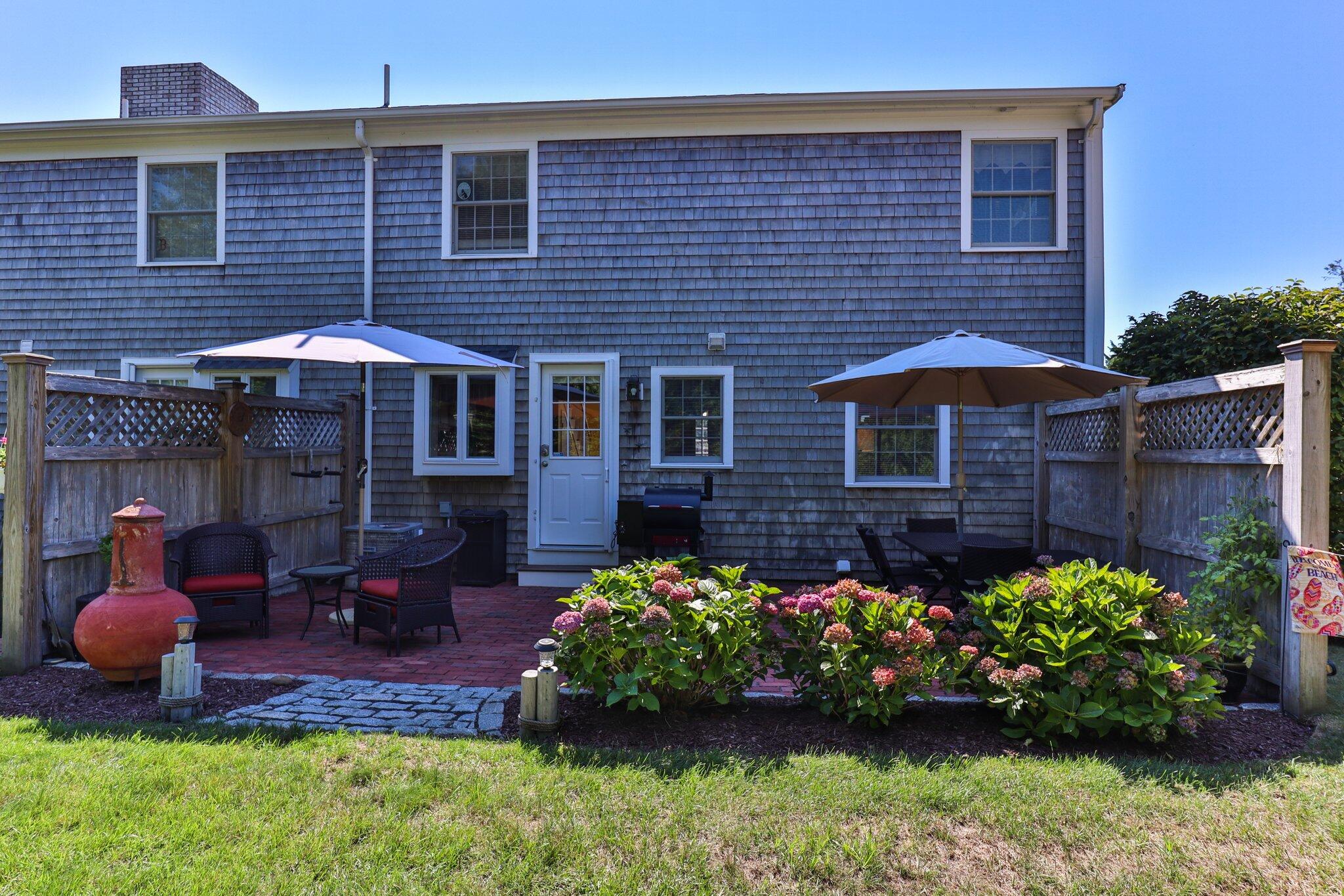 153 Jericho Path, Unit 8U Falmouth, MA 02540 - Photo 27 of 52 a front view of a house with a yard and outdoor seating