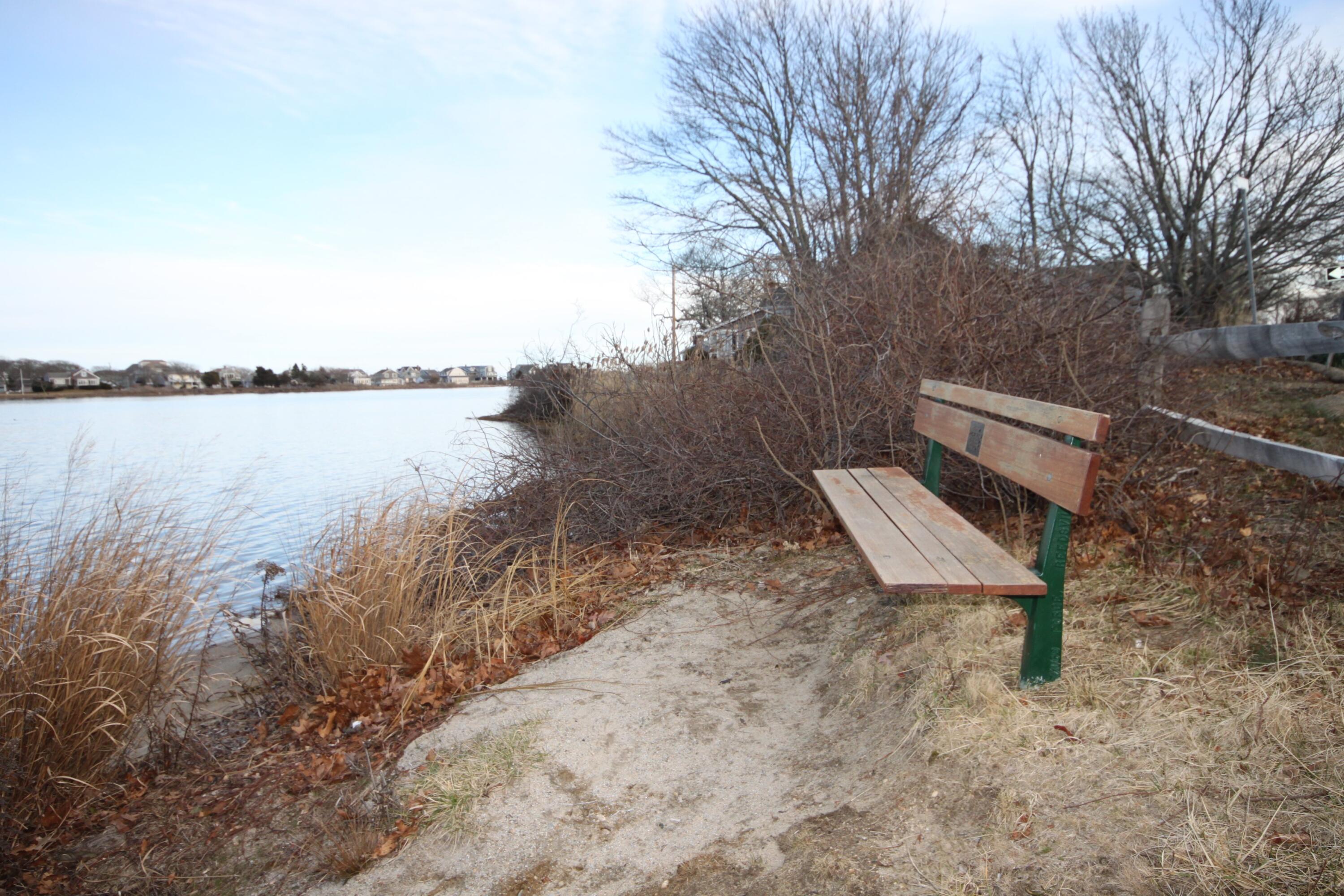 153 Jericho Path, Unit 8U Falmouth, MA 02540 - Photo 46 of 52 a view of a lake with a bench and trees
