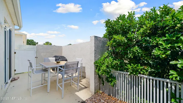 a view of a patio with table and chairs and potted plants