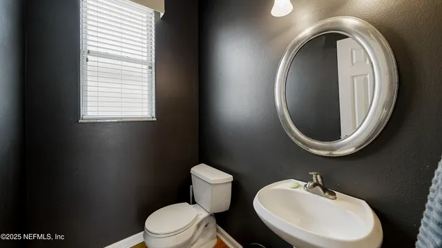 a bathroom with a toilet a sink and a mirror