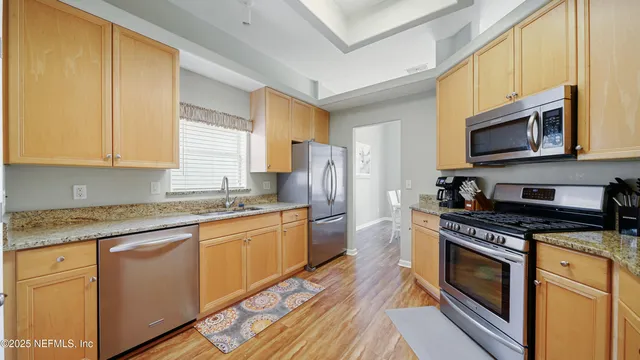 a kitchen with stainless steel appliances granite countertop a stove a sink dishwasher a refrigerator microwave and cabinets