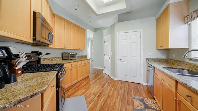 a kitchen with granite countertop wooden floors and wide window