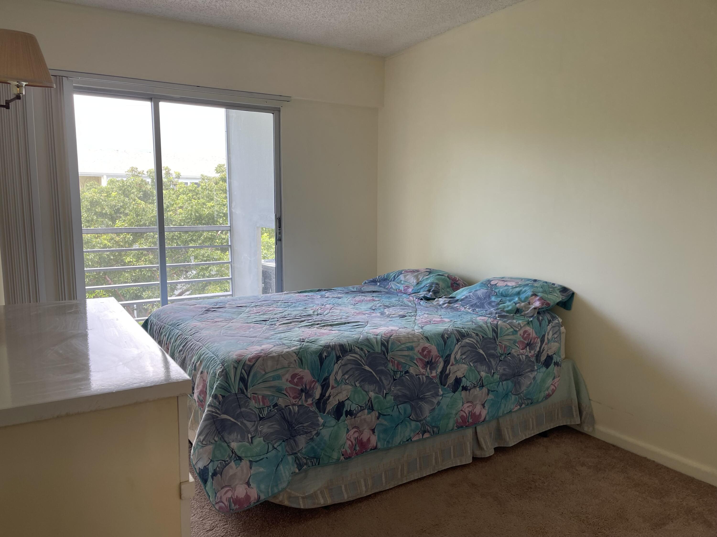 198 Dorset East, Unit E Boca Raton, FL 33434 - Photo 14 of 23 a bedroom with a bed and window