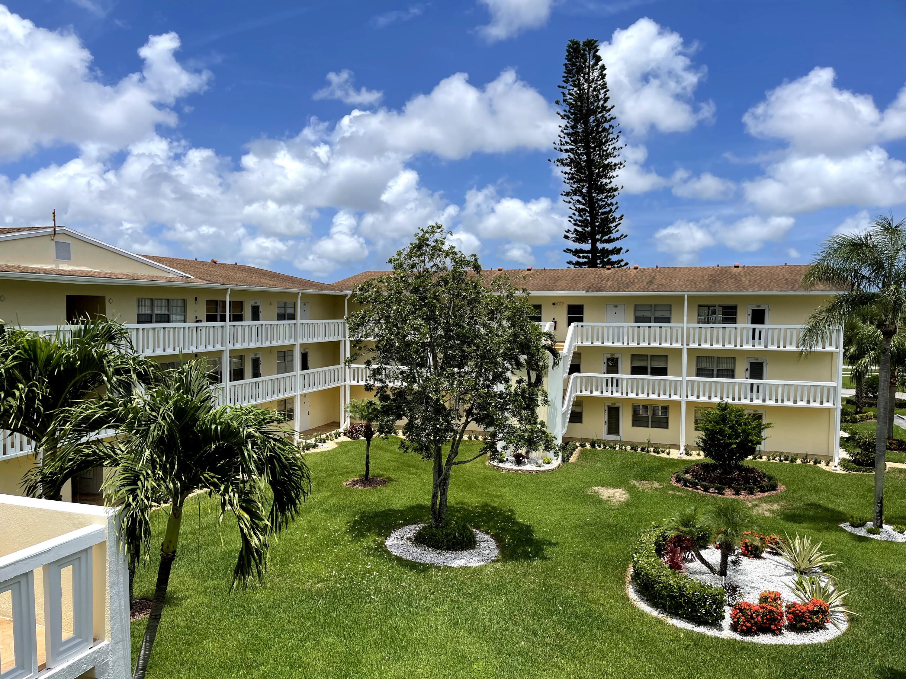 198 Dorset East, Unit E Boca Raton, FL 33434 - Photo 20 of 23 a front view of a house with a yard