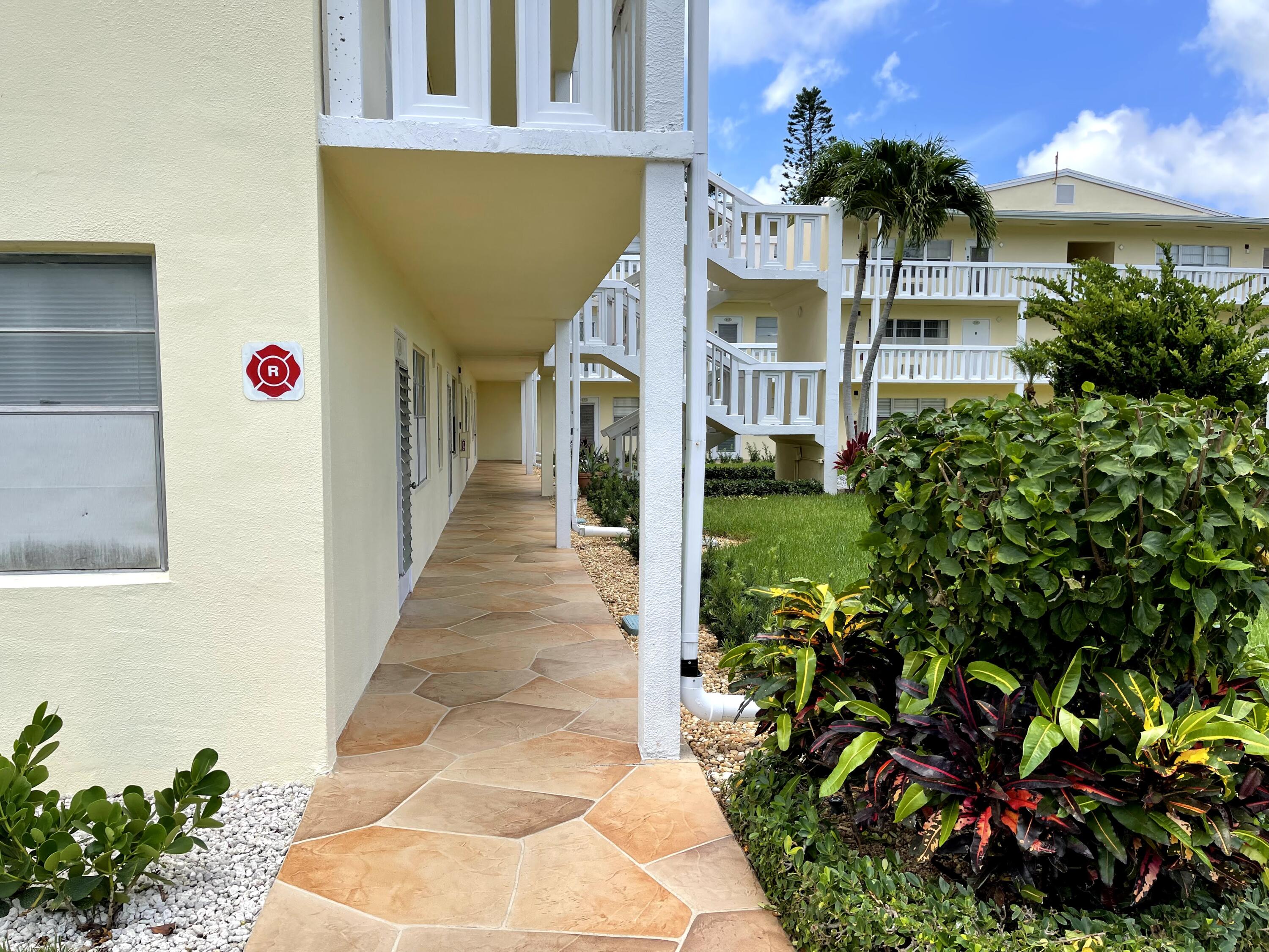 198 Dorset East, Unit E Boca Raton, FL 33434 - Photo 4 of 23 a front view of a house with a yard