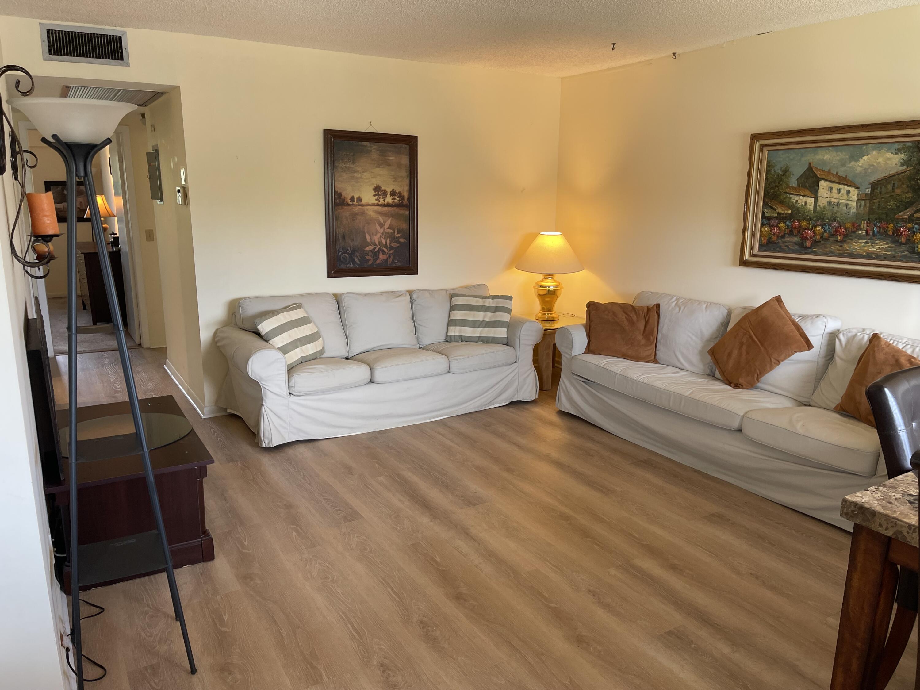 198 Dorset East, Unit E Boca Raton, FL 33434 - Photo 5 of 23 a living room with furniture and a lamp