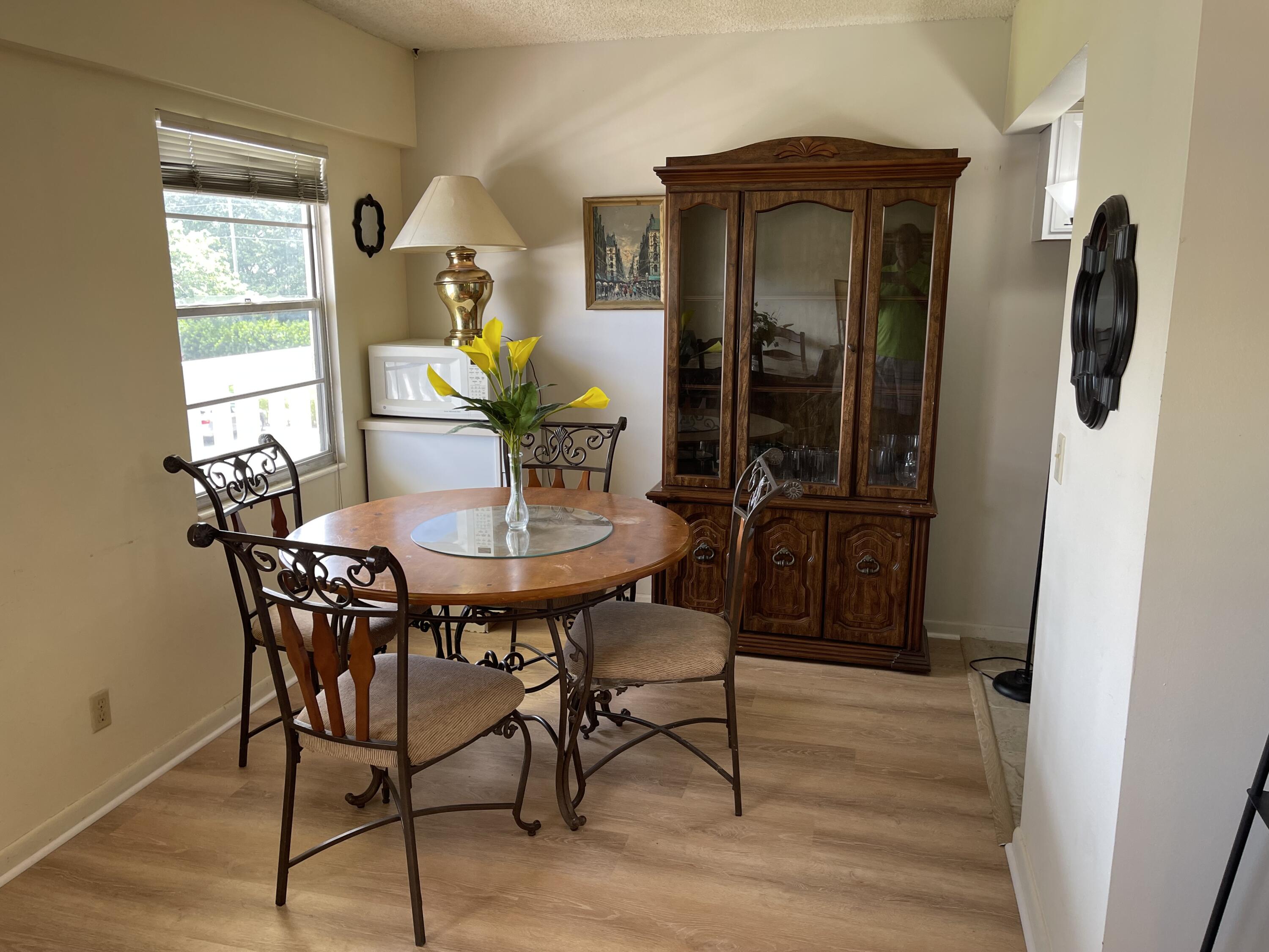198 Dorset East, Unit E Boca Raton, FL 33434 - Photo 7 of 23 a view of a dining room with furniture and window