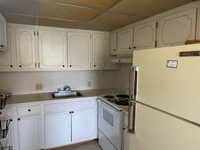 a kitchen with stainless steel appliances white cabinets and a refrigerator