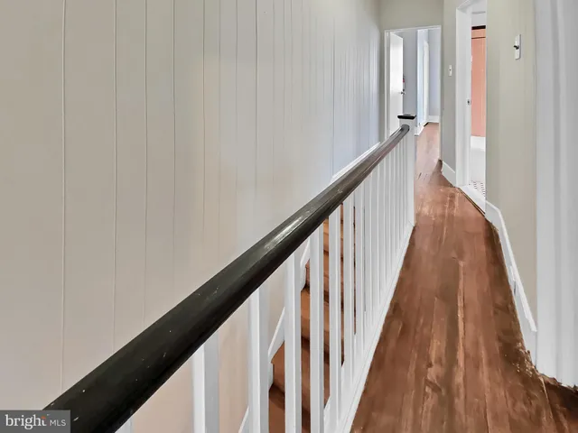a view of a hallway with wooden floor and staircase
