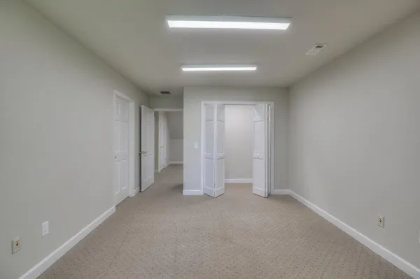 an empty room with windows and closet