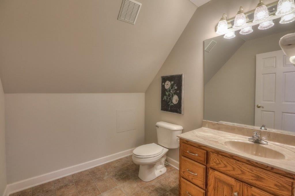1404 North Main Street Shelbyville, TN 37160 - Photo 24 of 27 a bathroom with a granite countertop toilet a sink and a mirror