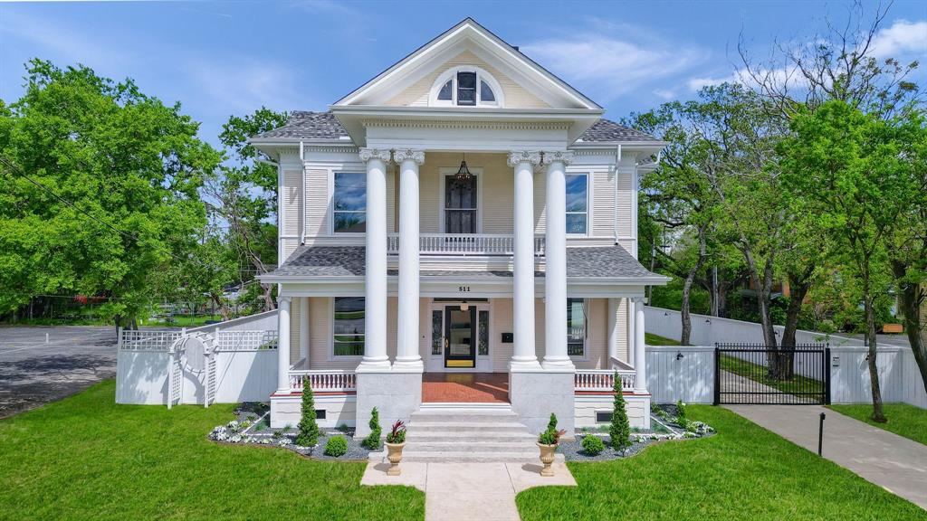 a front view of a house with a yard and trees