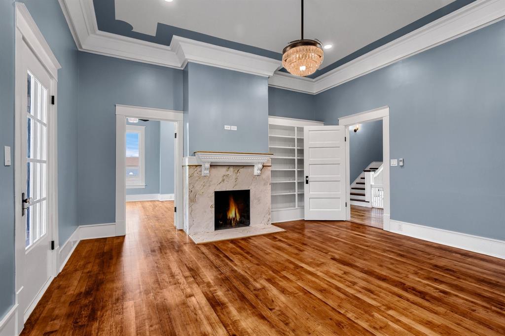 511 South Travis Street Sherman, TX 75090 - Photo 11 of 40 a view of a livingroom with a fireplace a chandelier and stairs