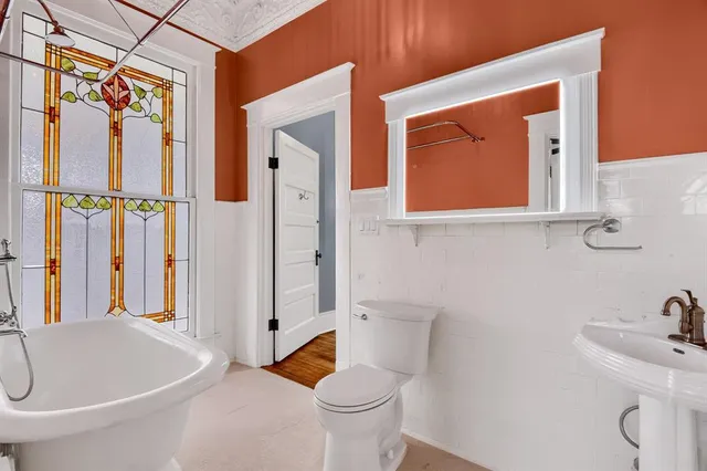 a bathroom with a toilet sink and mirror