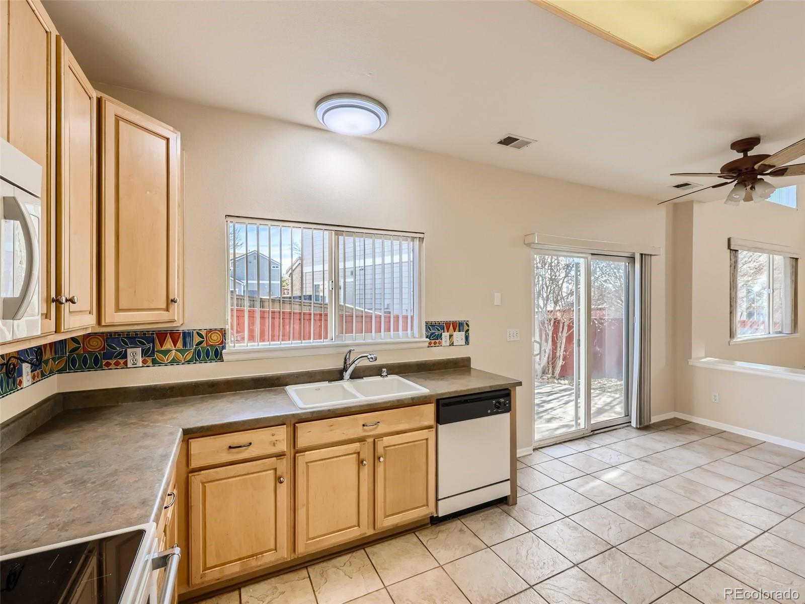 422 Chambers Way Aurora, CO 80011 - Photo 16 of 44 a kitchen with a sink and a refrigerator