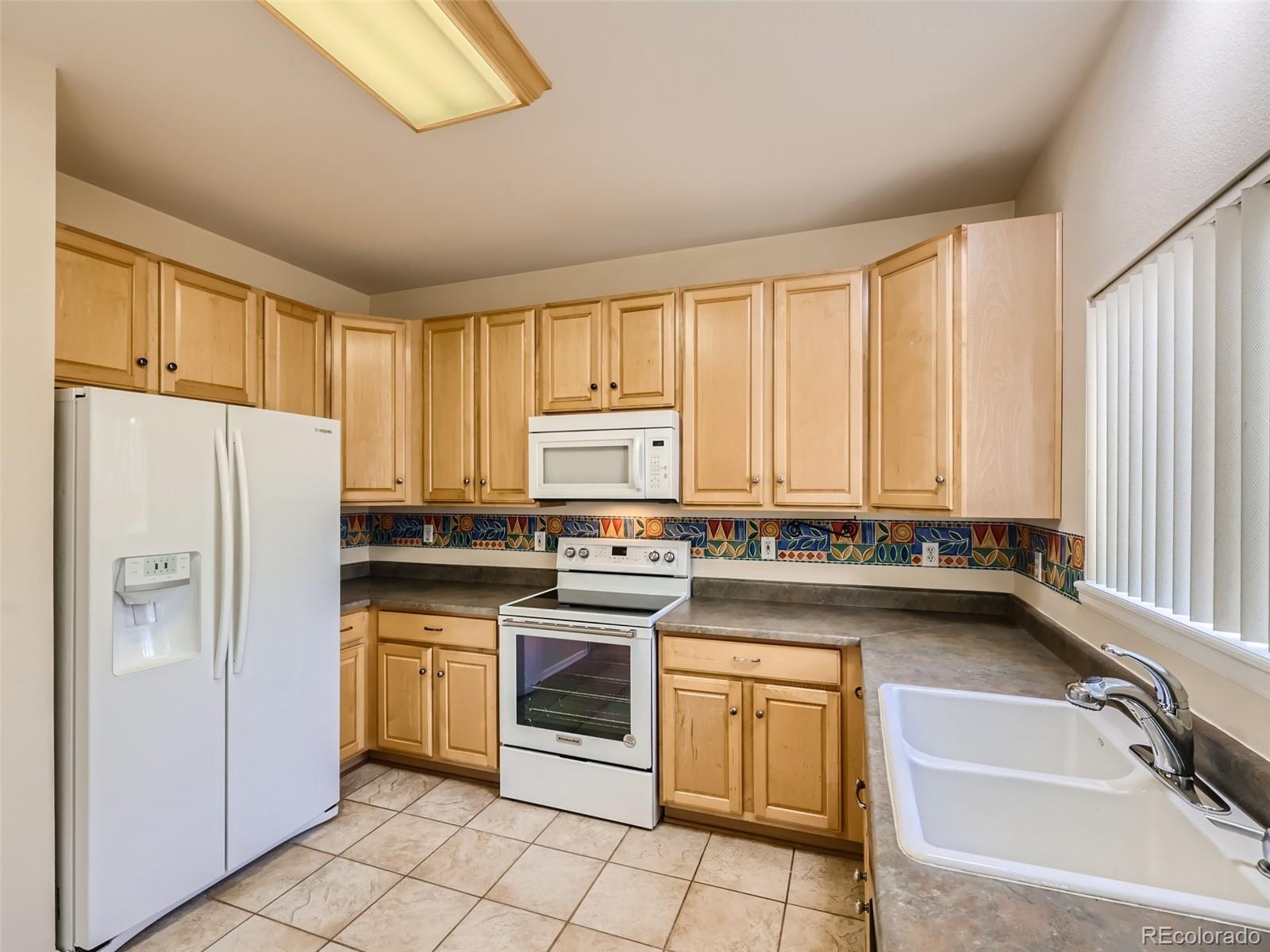 422 Chambers Way Aurora, CO 80011 - Photo 17 of 44 a kitchen with a refrigerator stove and sink