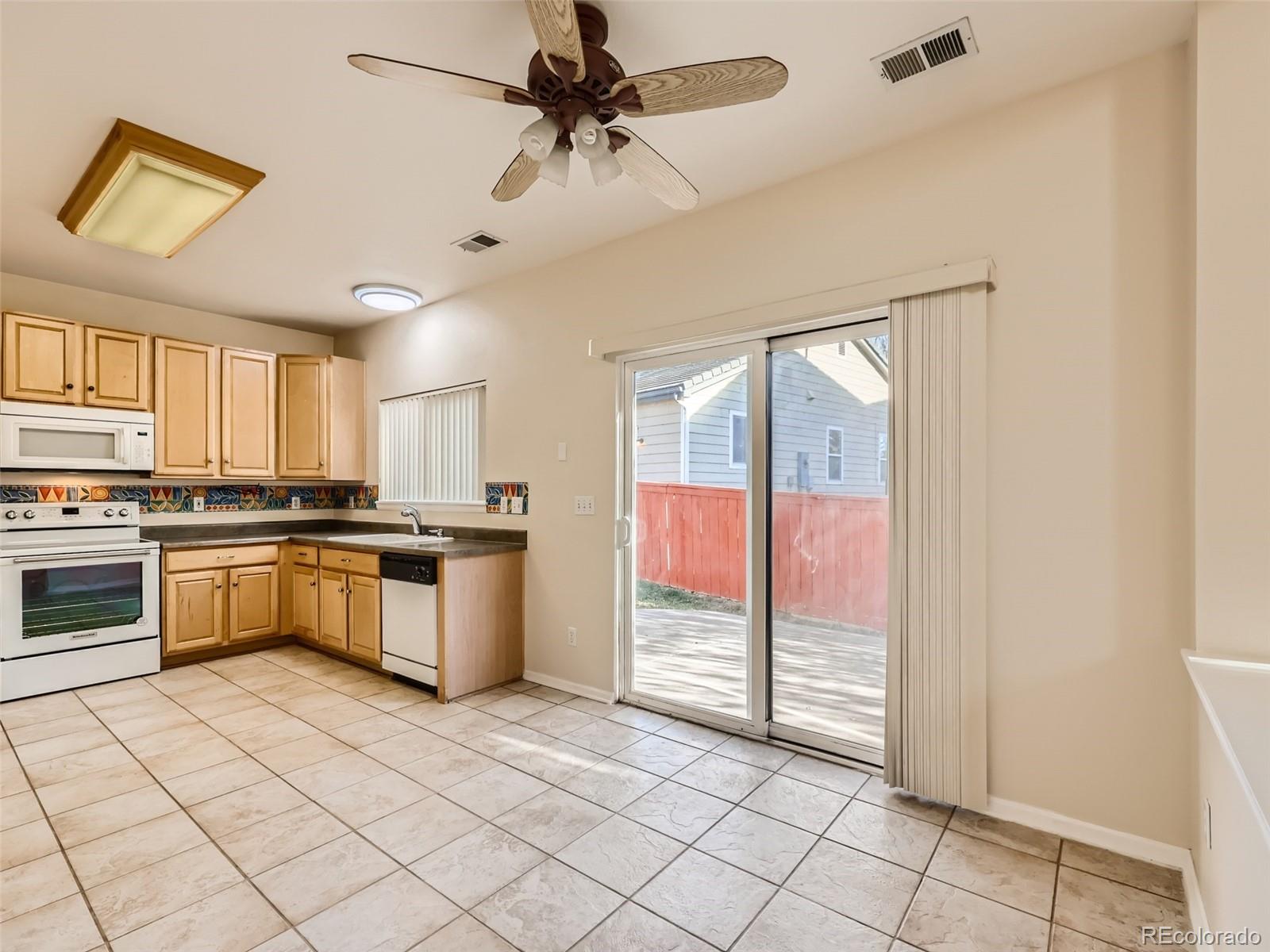 422 Chambers Way Aurora, CO 80011 - Photo 18 of 44 a kitchen with a stove a sink and a refrigerator