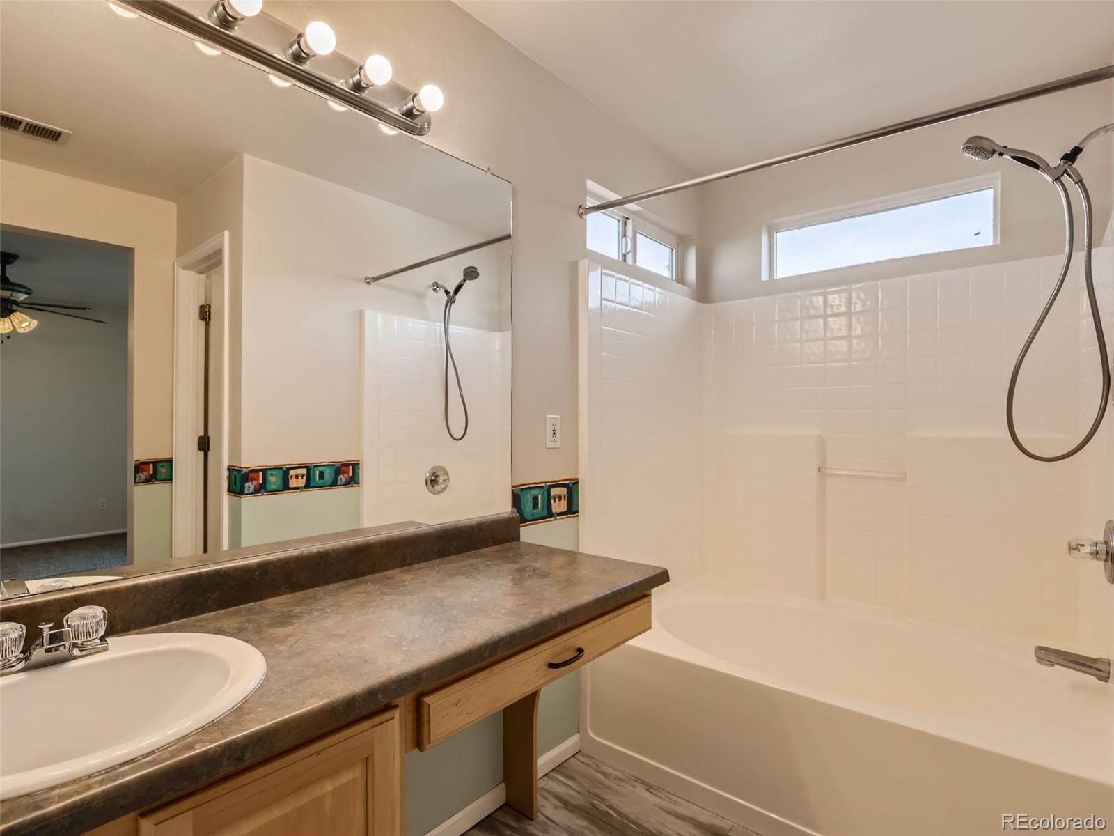 422 Chambers Way Aurora, CO 80011 - Photo 29 of 44 a bathroom with a granite countertop sink a shower and a mirror