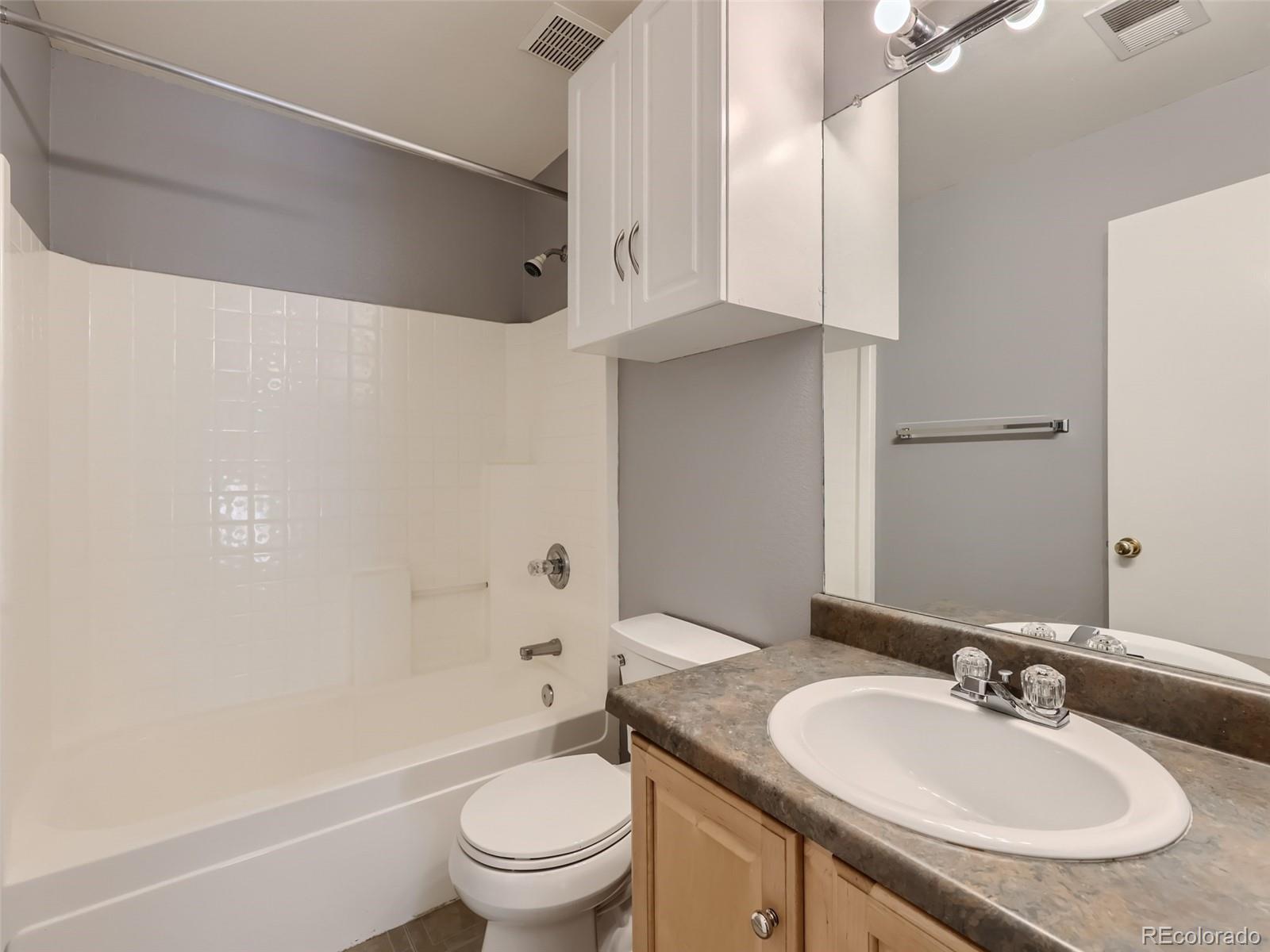 422 Chambers Way Aurora, CO 80011 - Photo 36 of 44 a bathroom with a granite countertop sink a toilet a mirror and shower