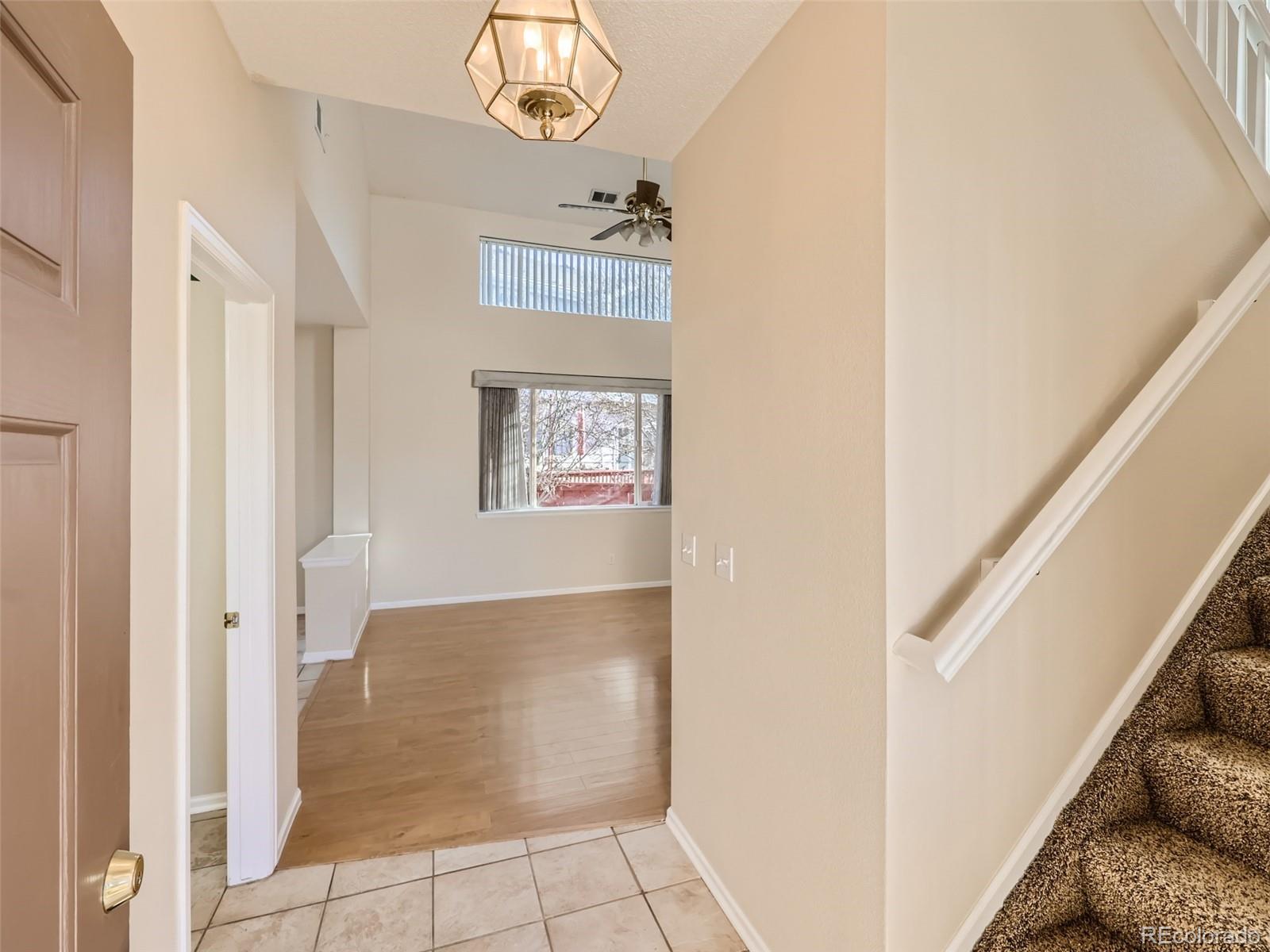 422 Chambers Way Aurora, CO 80011 - Photo 6 of 44 a view of a hallway with wooden floor and staircase