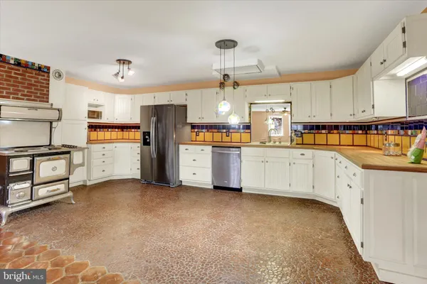 a kitchen with stainless steel appliances a refrigerator sink and cabinets