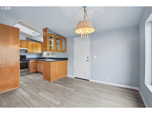 a kitchen with stainless steel appliances a stove and wooden floor