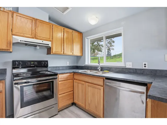 a kitchen with stainless steel appliances granite countertop a stove a sink and a microwave