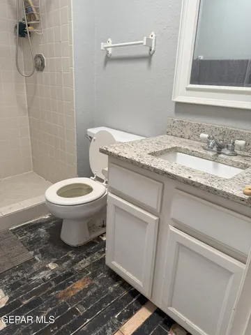 a bathroom with a granite countertop toilet sink and mirror