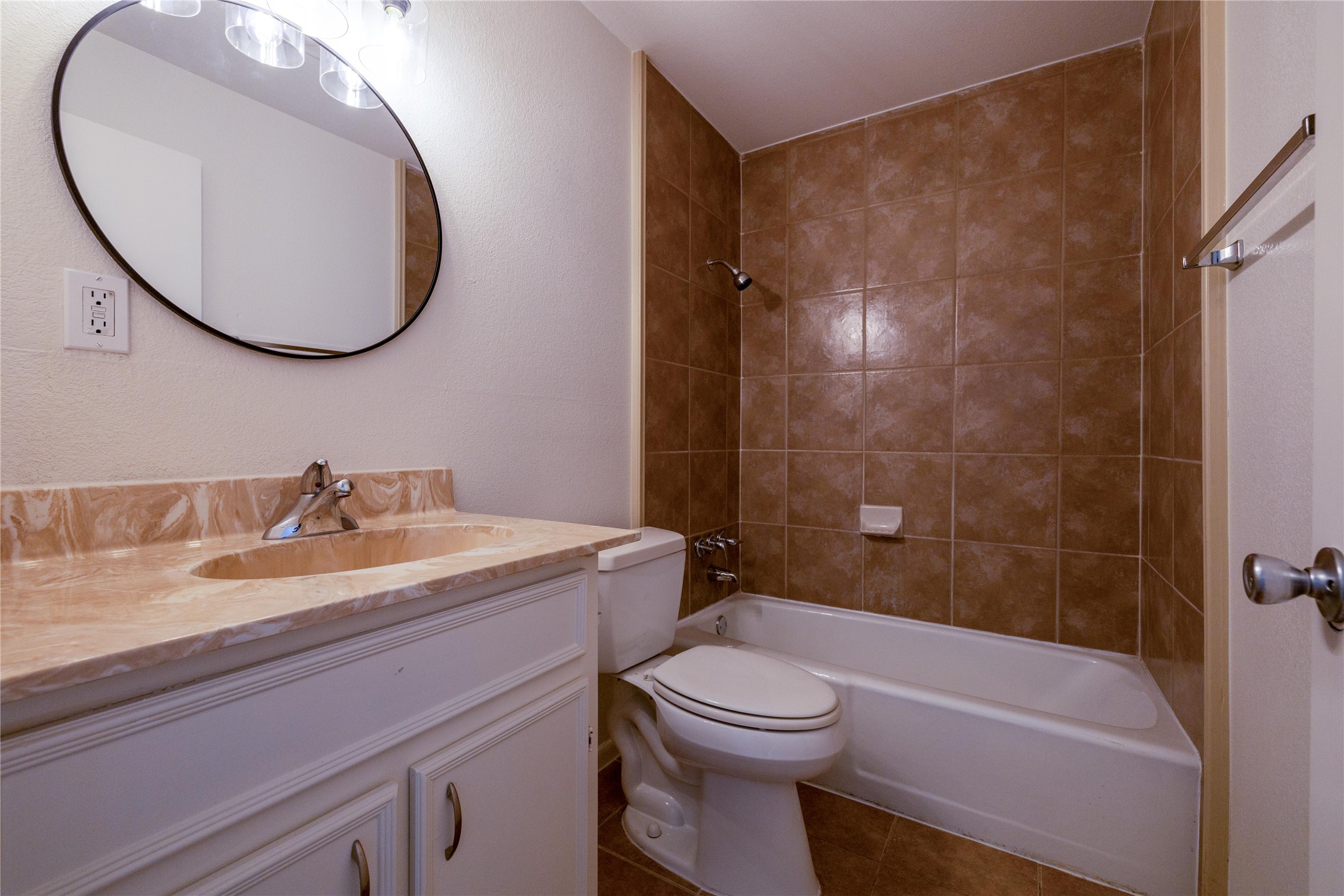 4304 Scottsdale Road Austin, TX 78721 - Photo 13 of 21 Full bathroom with vanity, shower combination, dark tile patterned floors, and a textured wall