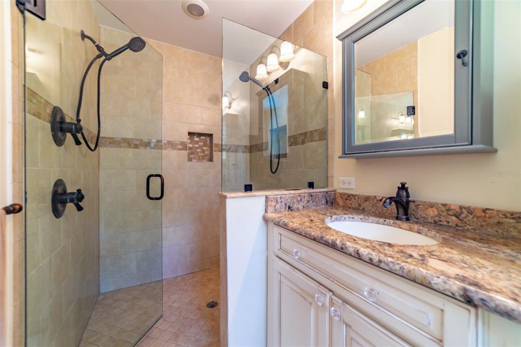 4201 West Dale Avenue Tampa, FL 33609 - Photo 38 of 77 a bathroom with a granite countertop shower a mirror and a sink