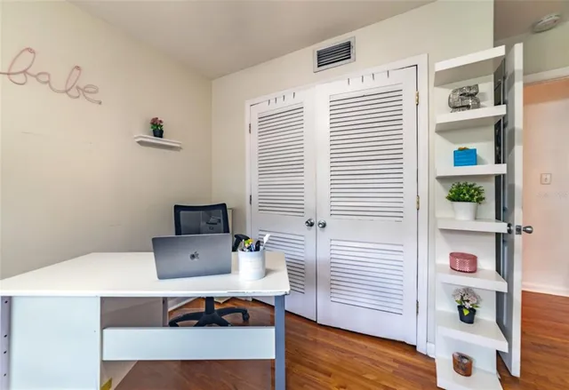 a view of a house with a big yard potted plants and large tree