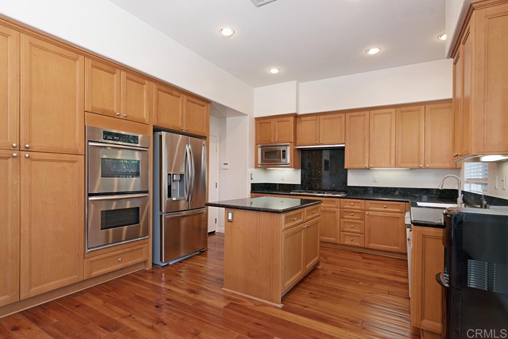 1445 Ranch Road Encinitas, CA 92024 - Photo 11 of 22 a kitchen with stainless steel appliances granite countertop a refrigerator a stove top oven a sink and dishwasher with wooden floor