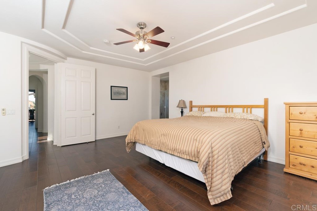 1445 Ranch Road Encinitas, CA 92024 - Photo 15 of 22 a bedroom with a large bed and a chandelier