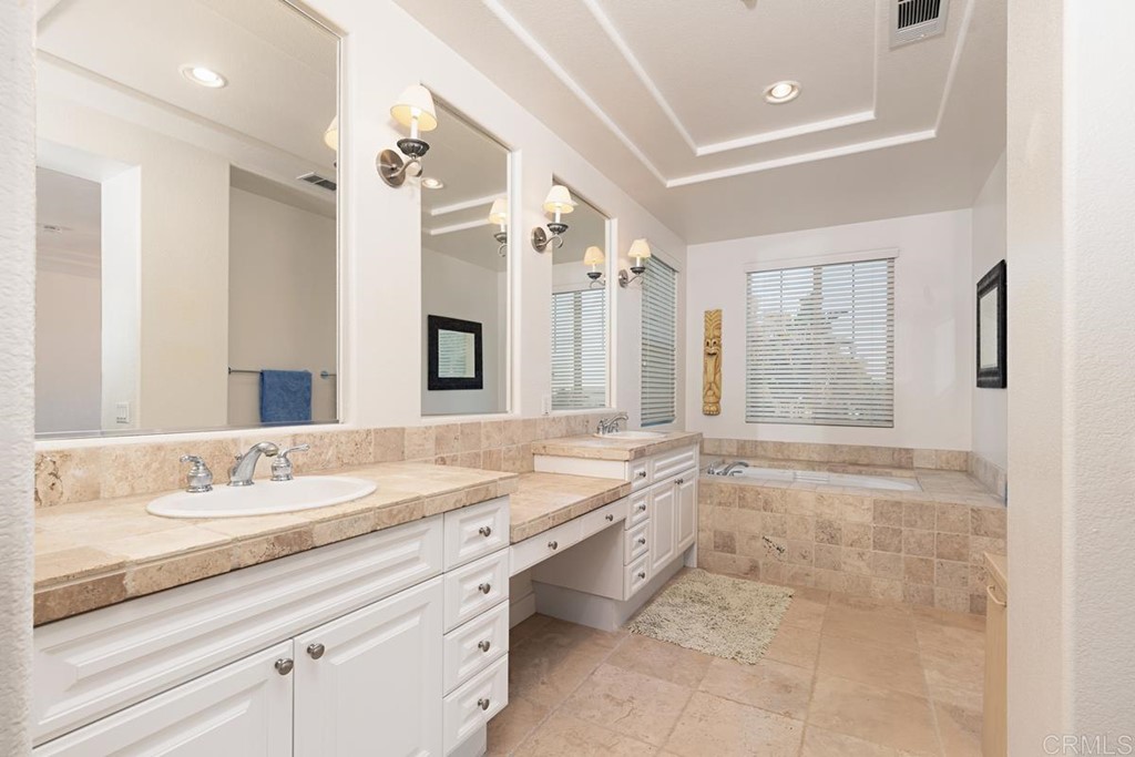 1445 Ranch Road Encinitas, CA 92024 - Photo 17 of 22 a bathroom with a granite countertop double vanity sink toilet mirror bathtub and window