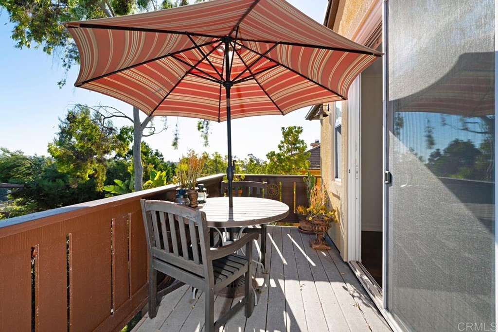 1445 Ranch Road Encinitas, CA 92024 - Photo 19 of 22 a view of a balcony with a table and chairs under an umbrella