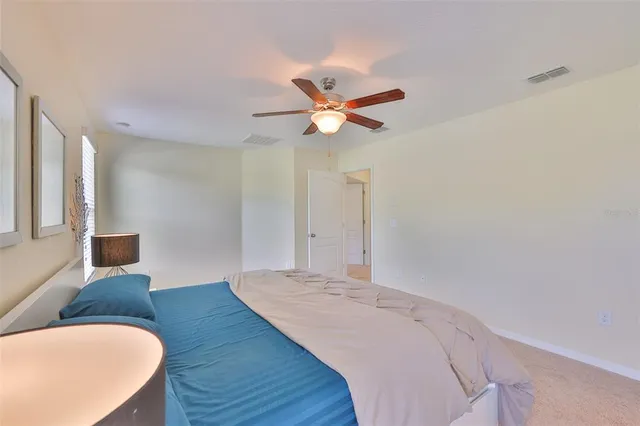 a bedroom with a bed and a ceiling fan